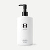 White bottle with black pump and 'One Skin' logo on a beige background