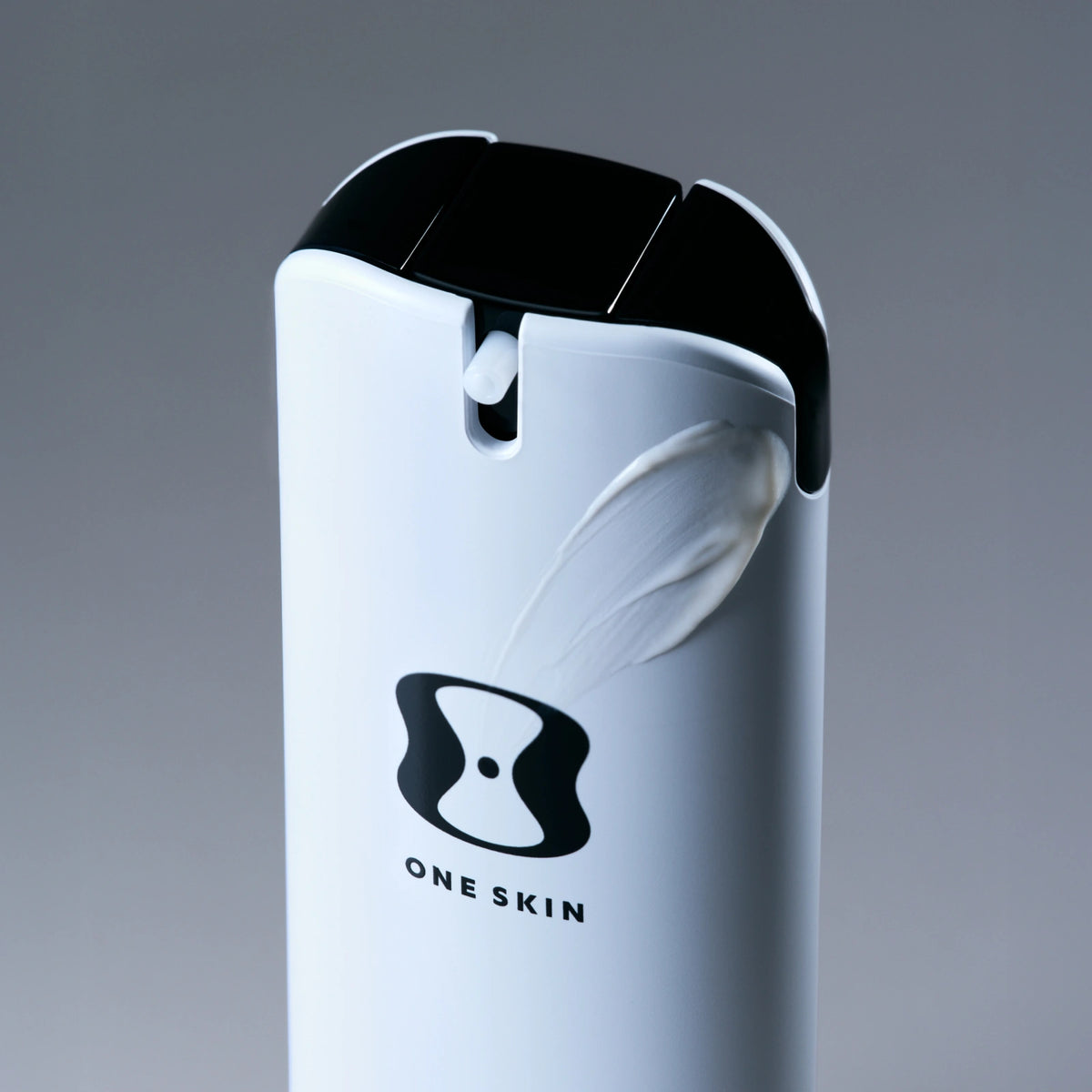 Skincare product with 'ONE SKIN' branding on a gray background
