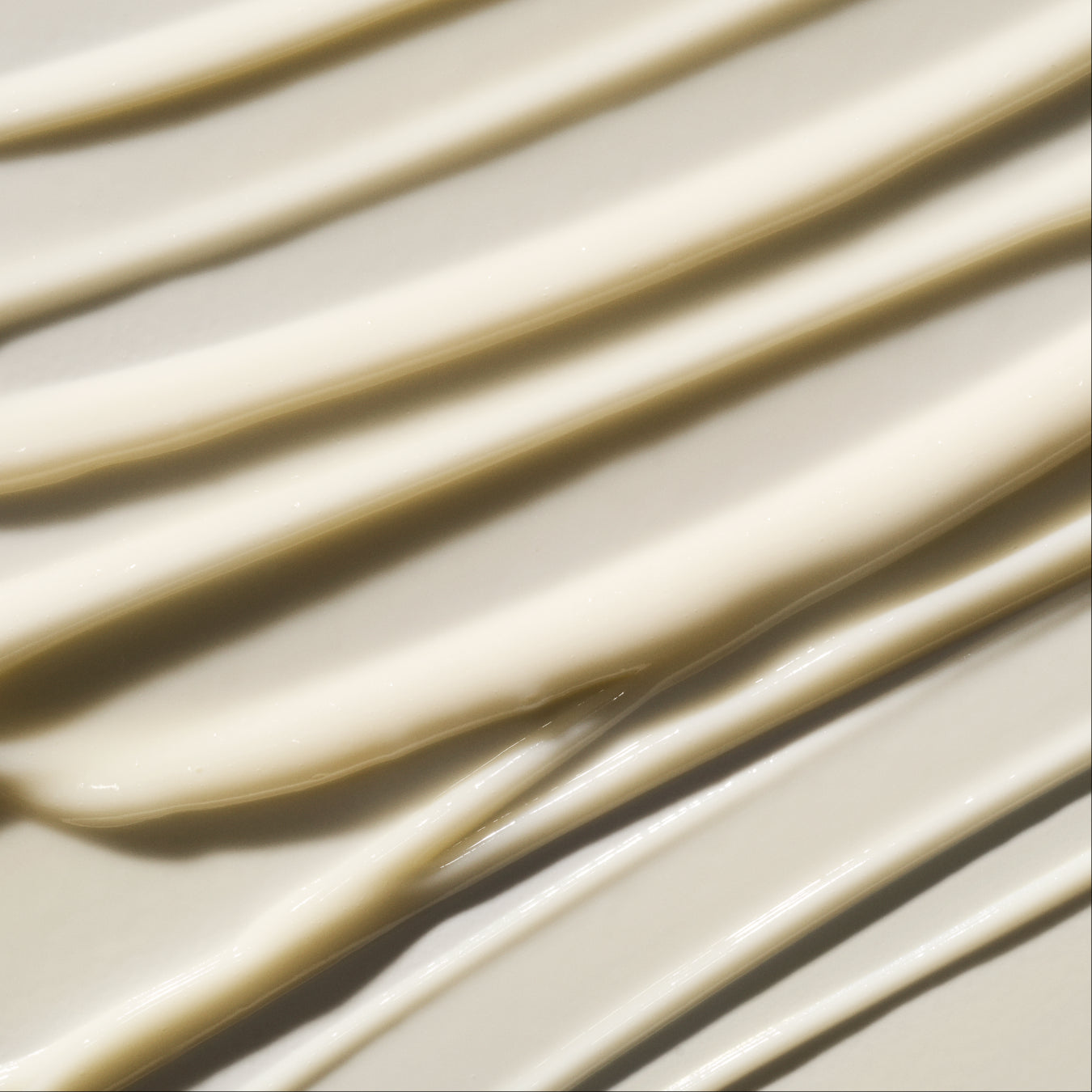 A close-up texture shot of a thick, creamy OS-01 BODY MOISTURIZER, swirled in diagonal strokes that create soft shadows.