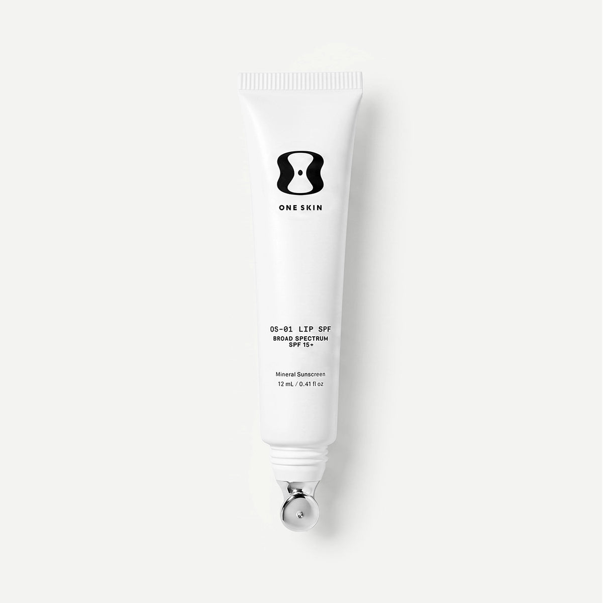 A white squeeze tube of ONE SKIN LIP SPF 15 with a silver applicator, shown against a light gray background.