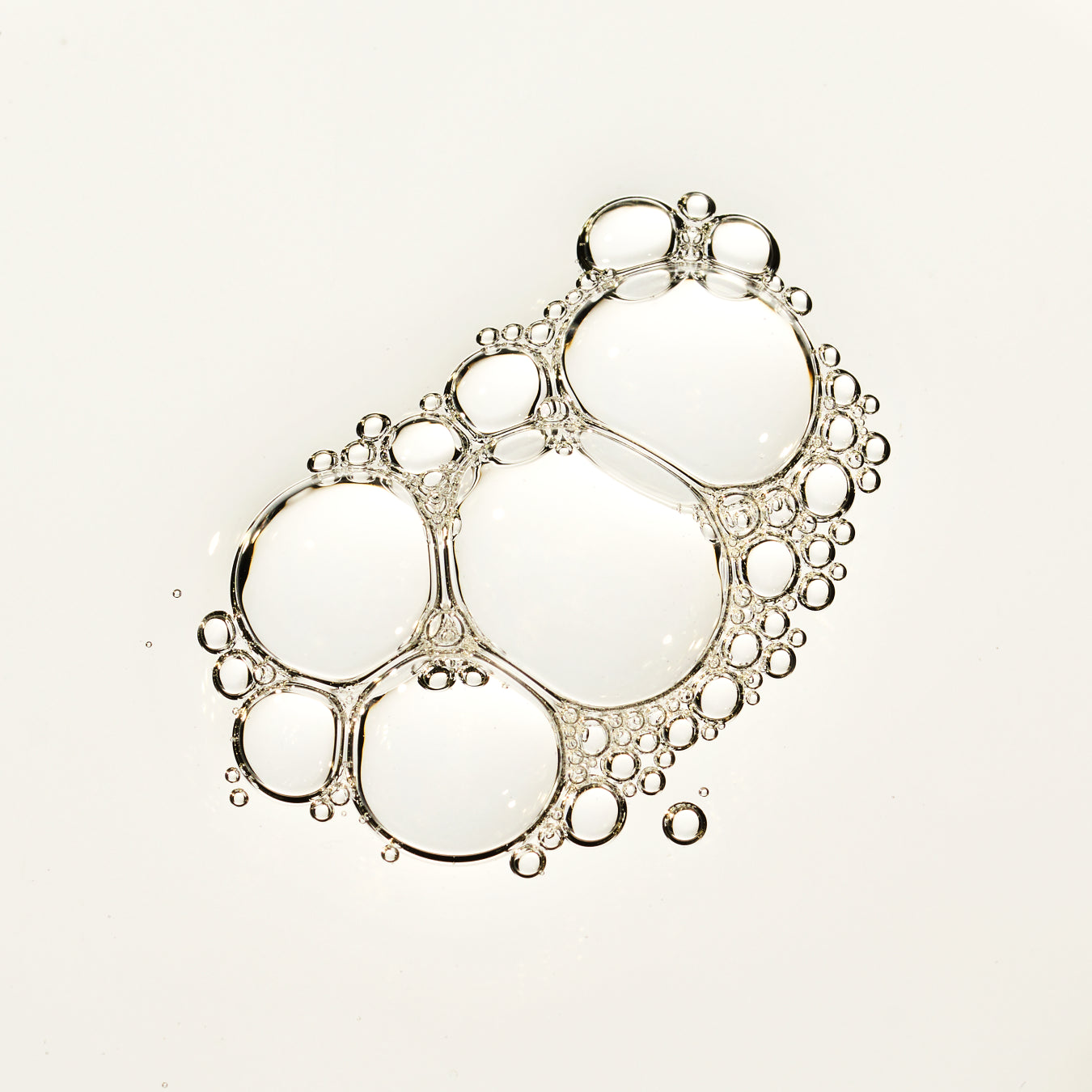 A cluster of clear, bubble-like droplets with silver outlines arranged on a plain white background.