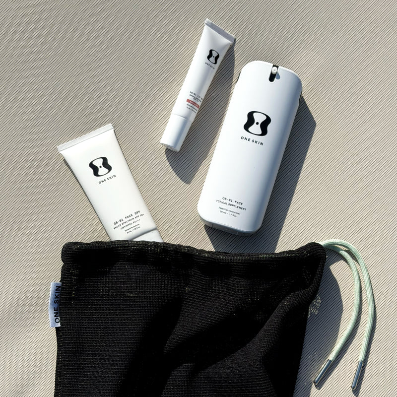 Three skincare products with a black drawstring bag on a beige surface
