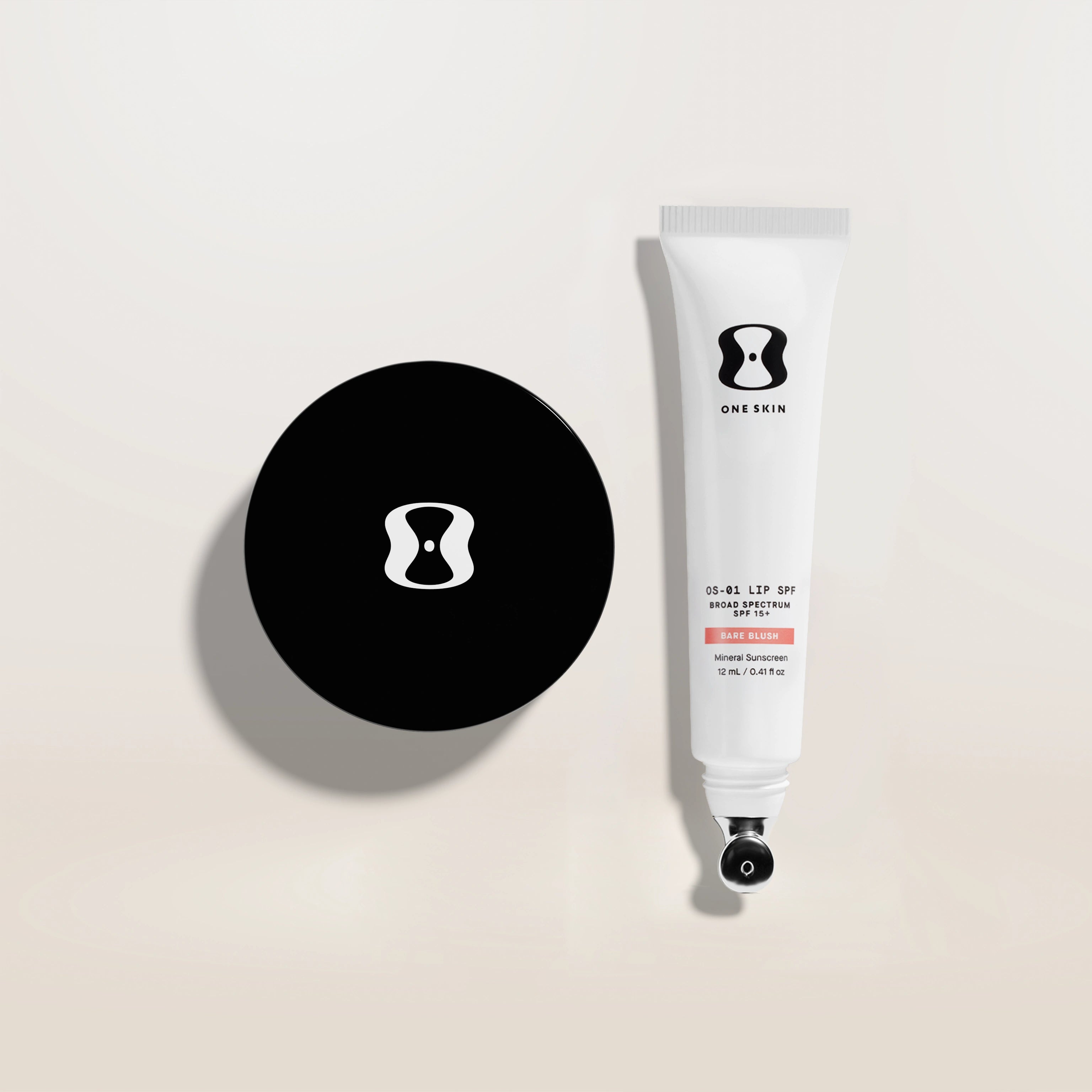 Skincare product packaging with black disc and white tube on a beige background