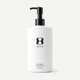 White bottle with black pump and 'One Skin' logo on a beige background