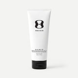 Tube of One Skin body SPF cream on a beige background