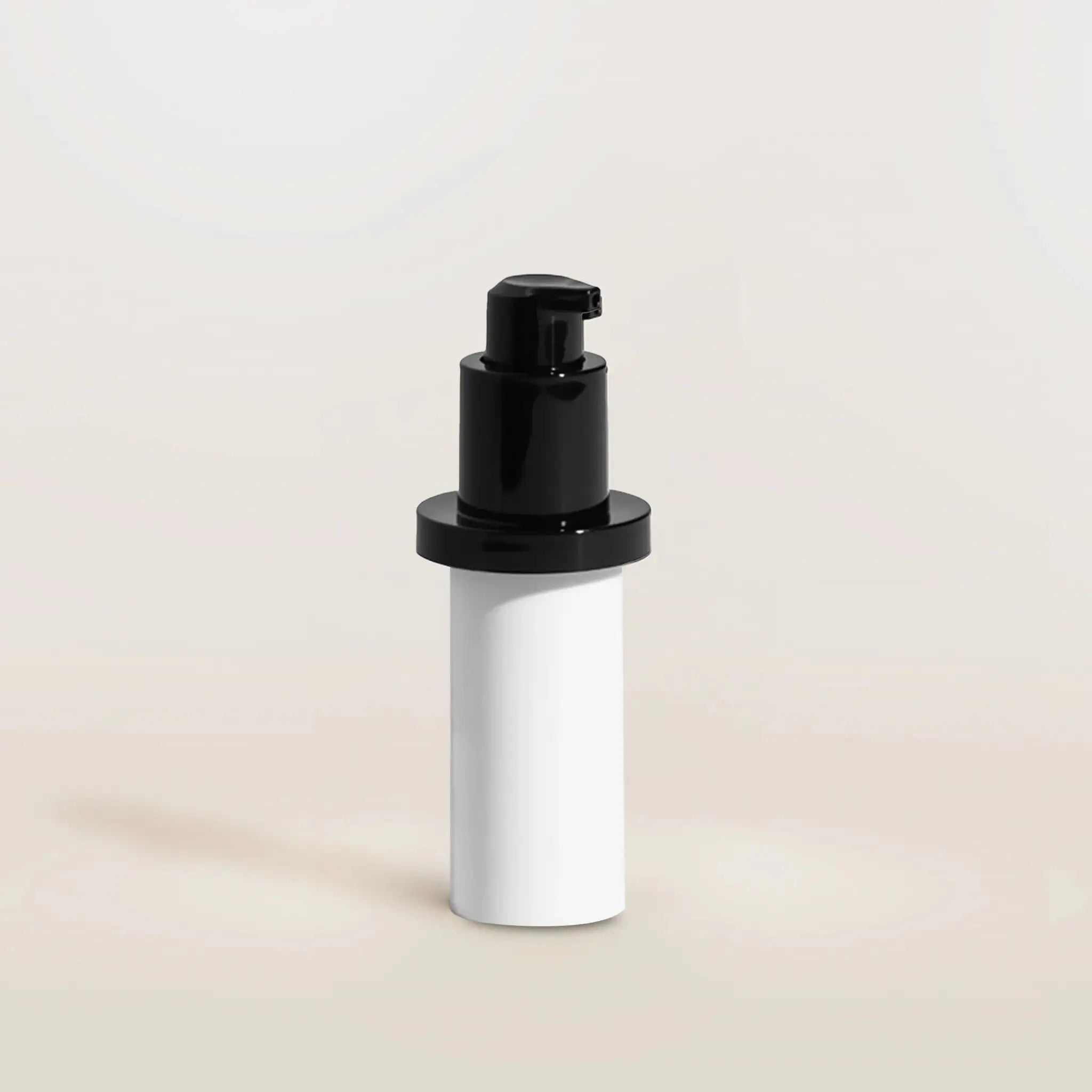 White cylindrical container with black pump on a beige background