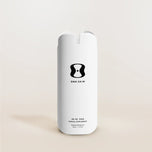 White supplement bottle labeled 'One Skin' on a beige background