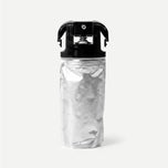 Silver refill package with black cap on a light beige background
