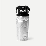 Silver refill package with black cap on a light beige background
