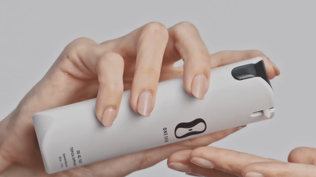 Woman applying OneSkin moisturizer product