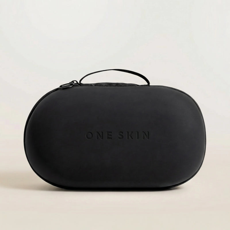 Black travel case with 'ONE SKIN' branding on a beige background